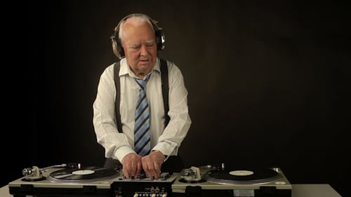Elderly Man Mixing Music on Turntables