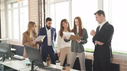 Group of a Young Business People Brainstorming and Discussing Business Plan in Office