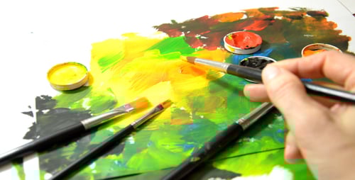 Artist Painting with Bright Colors on White Surface