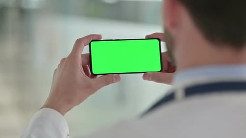 Person Holds Phone with Green Screen in Hospital