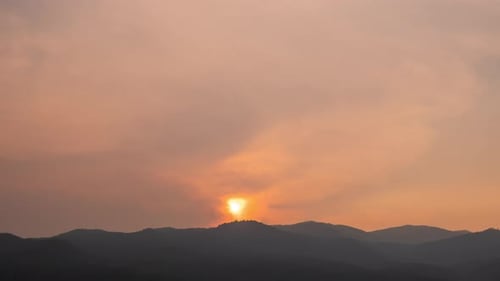 Lapso de tiempo de Dramático puesta de sol con cielo naranja en un día soleado.