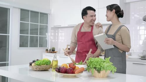Couple Cooking Salad Together in Bright Kitchen