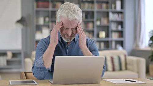 Tired Old Man Having Headache in Office