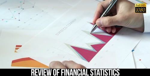 Man Analyzes Financial Graphs and Charts at Desk
