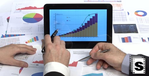Hands Reviewing Business Data with Pens and Tablet