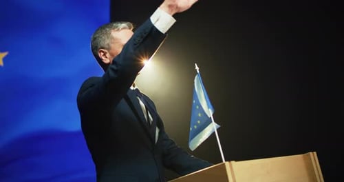 Man Speaking at Podium with European Union Flag
