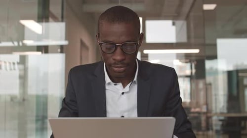 Adult Using Laptop in Modern Office Environment