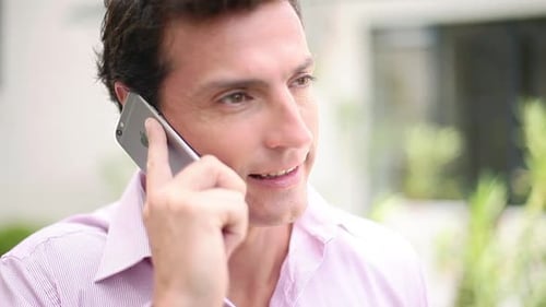 Hombre hablando por teléfono celular y sonriendo