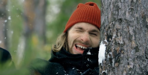 Young Adult Hit by Snowball in Winter Forest