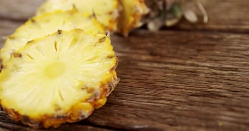 Sliced Pineapple Rings on Wood Background