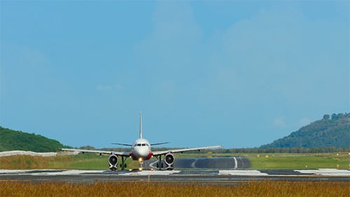 Airplane Landing on Tropical Runway on Bright Day