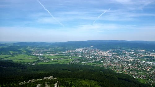A Small Town Surrounded By a Forest, the Bright Blue Sky in the Background - Top View