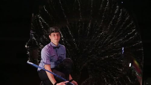 Young Man Makes Giant Bubbles at Night