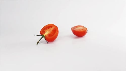 Two Halves of Tomato Breaks Hitting White Surface