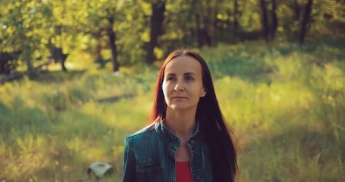 Nettes Mädchen geht durch den Wald und lächelt. Sommerspaziergang im Wald. Portrait-Ansicht