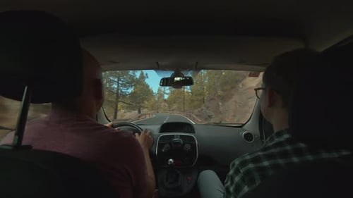 A View of a Mountain Road From a Backseat of a Moving Car
