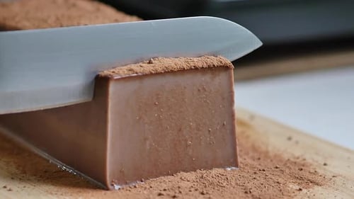 Nahaufnahme des Messers beim Schneiden von Schokoladenpudding
