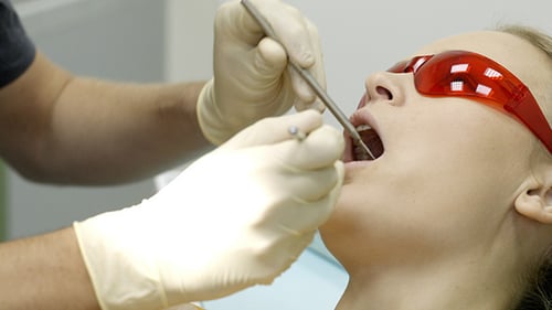 Dentist Examines Woman Patient with Tools, Close Up