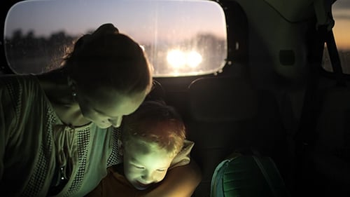 Mother and Child Using Tablet in Back of Car