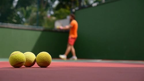 Man Hits Tennis Ball Against Wall for Practice