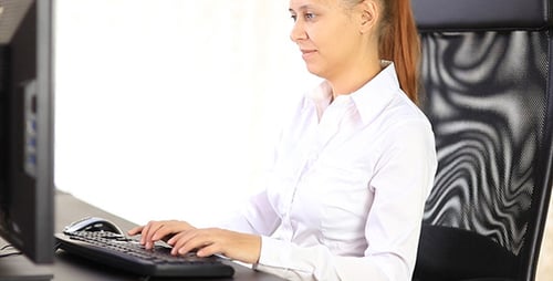 Woman Typing on Keyboard in Bright Office