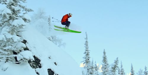 Skier Jumps Off Snowy Mountain Top in Winter