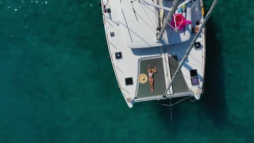 Frau im Bikini beim Bräunen und Entspannen auf einer Katamaran-Segelkreuzfahrt