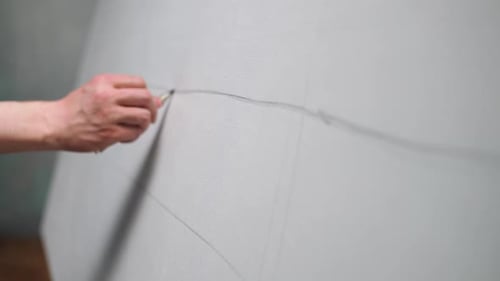Art Studio Creative Man at Work a Talented Artist Makes Sketches on Canvas with a Pencil Draws Lines