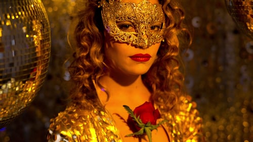 Woman in Gold Mask Holds Rose Among Disco Balls