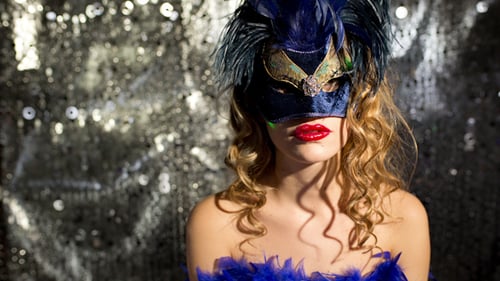 Masked Woman Poses with Sparkly Silver Backdrop