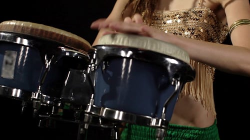 Woman with dreadlocks playing bongo drums