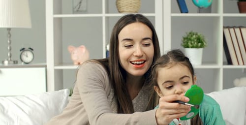Mother and Daughter Apply Makeup Together at Home
