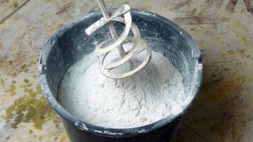 Mixing White Powder into Paste with Metal Tool