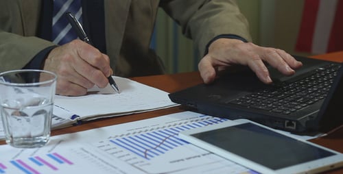 Professional Hands Using Laptop and Tablet in Office