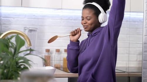 Woman Enjoying Music and Dancing in Kitchen