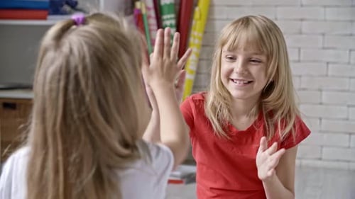 Girls Play Hand-Clapping Game Together Indoors