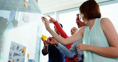 Team Brainstorming Ideas on Whiteboard in Modern Office