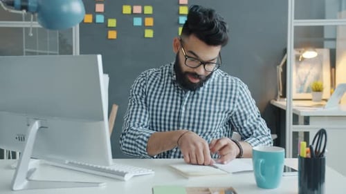 Young Adult Working at Computer in Modern Office