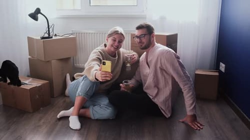 Couple Celebrating New Home with Selfie and Boxes