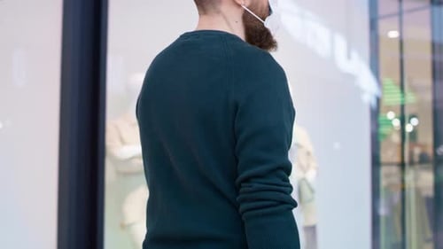 Video of man in protective mask strolling in shopping mall. Shot with RED helium camera in 8K.