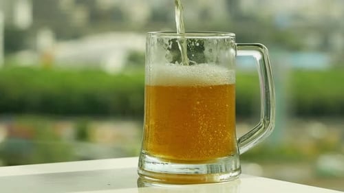 Golden Beer Pouring into Glass Mug