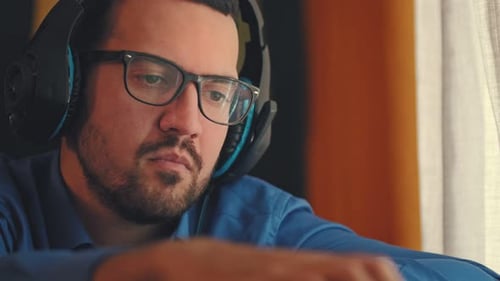 Focused Man with Headphones Watching Phone Indoors