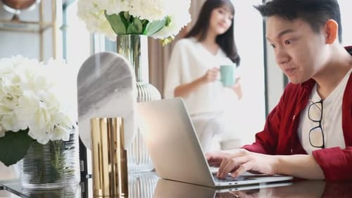 Young Adults Working Together at Home on Laptop