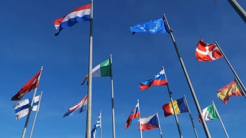 Various National Flags Waving Against Bright Blue Sky