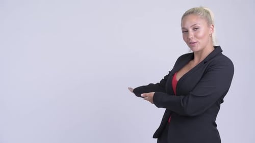 Smiling Woman in Business Suit Presenting to the Side