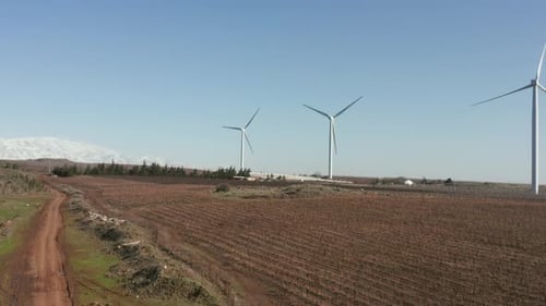 Wind turbines spin in a rural mountain landscape, Aerial view.