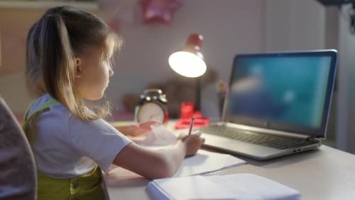 Girl Doing Homework with Laptop at Desk