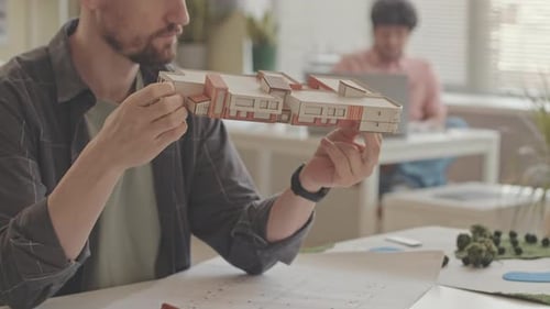 Architect Examining Building Model in Office Workplace
