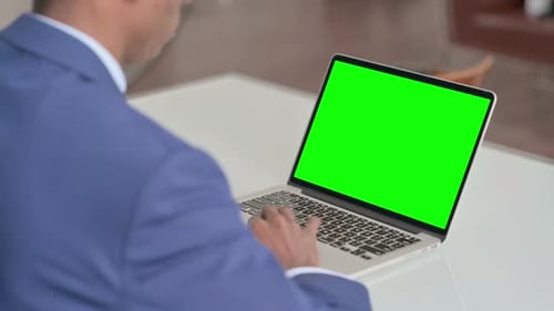 Young African Businessman Using Laptop with Green Screen