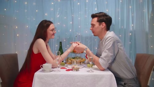 Young Couple Holding Hands at Romantic Dinner